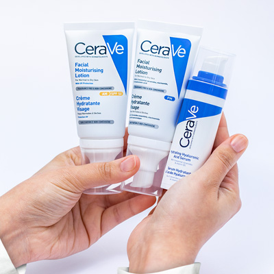 A woman hands holding AM Facial Moisturising Lotion, PM Facial Moisturising Lotion, and Hydrating Hyaluronic Acid Serum